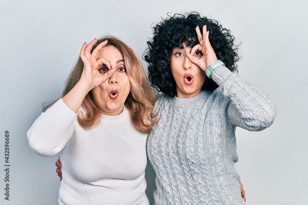 Middle east mother and daughter wearing casual clothes doing ok gesture shocked with surprised face, eye looking through fingers. unbelieving expression. Middle east mother and daughter wearing casual clothes doing ok gesture shocked with surprised face, eye looking through fingers. unbelieving expression.