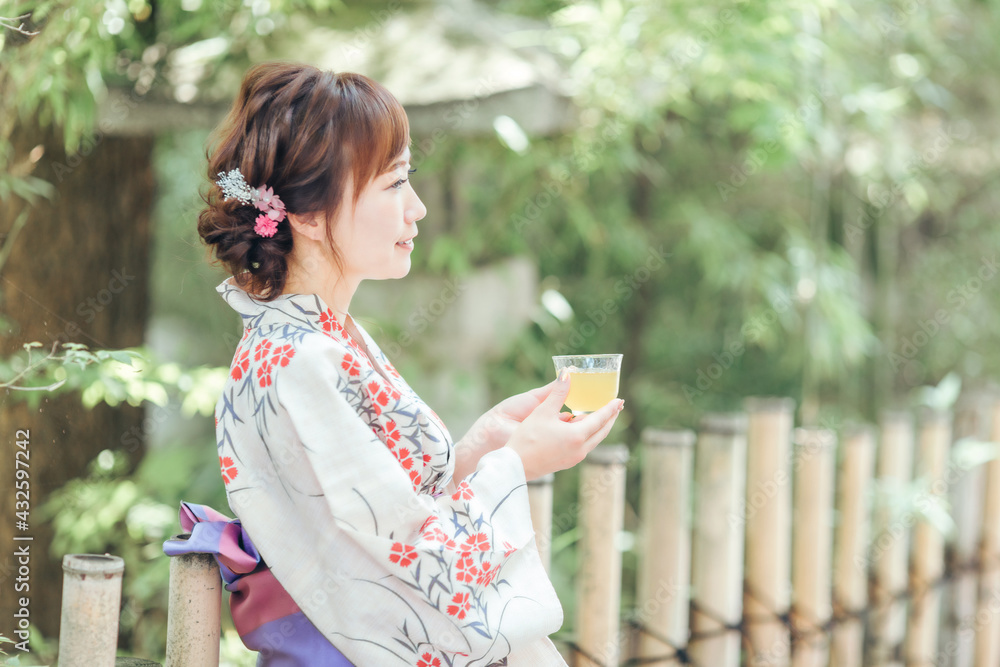飲み物を飲む浴衣姿の女性
