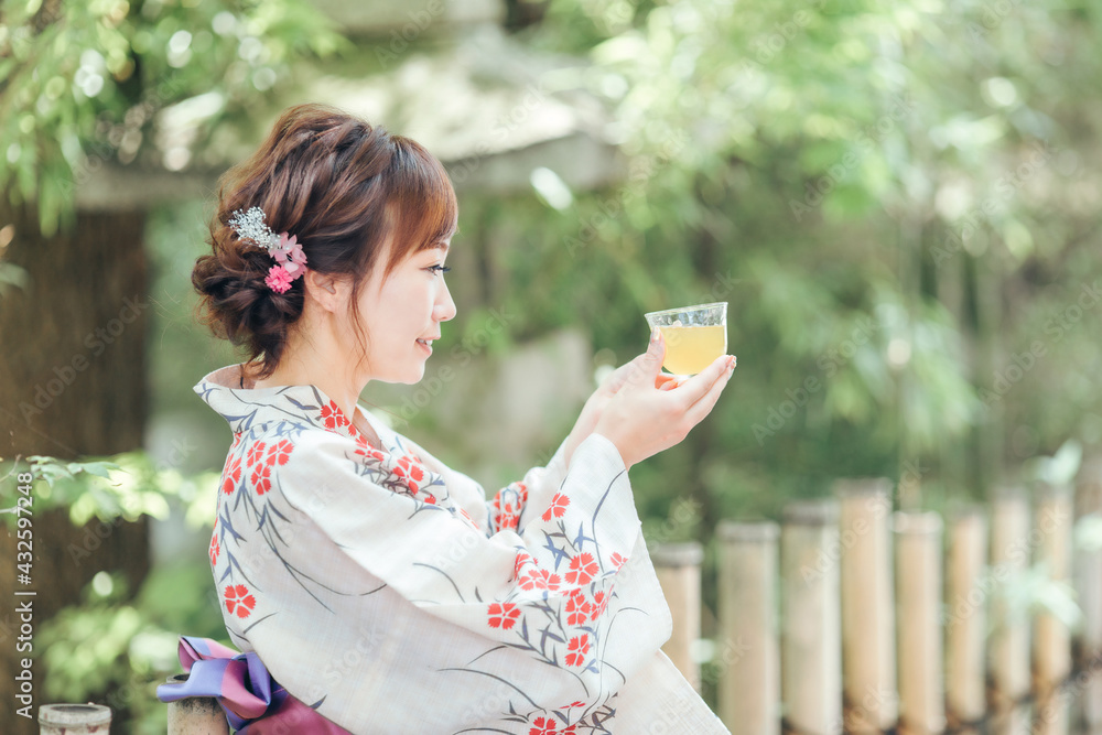 飲み物を飲む浴衣姿の女性
