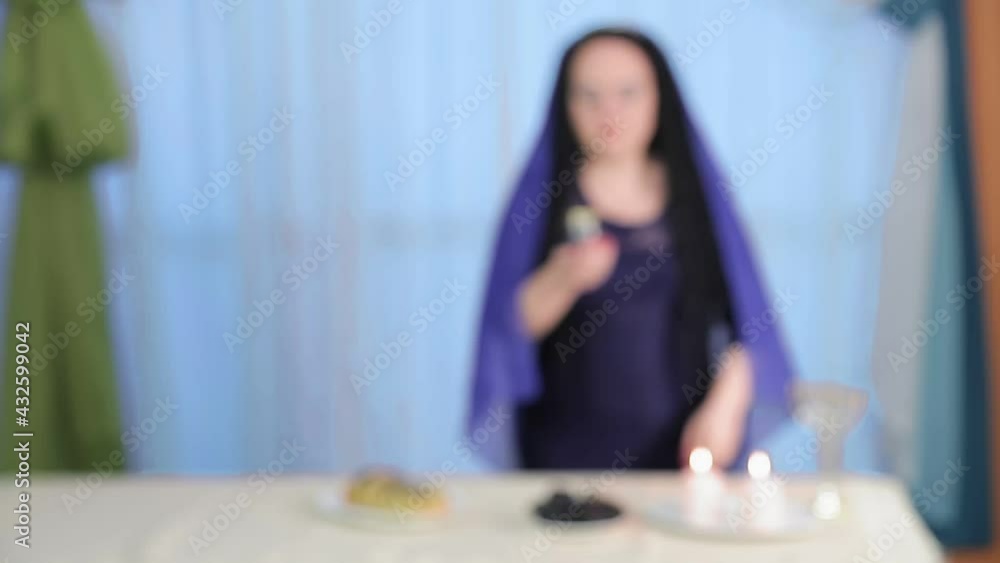 A Jewish woman conducts the ceremony of meeting the Shabbat from blur to sharpness A Jewish woman conducts the ceremony of meeting the Shabbat from blur to sharpness