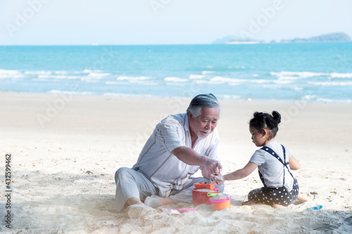 Grandfather and little granddaughter having fun on summer vacation on the beach seaside together.Happy family on the beach, Holiday travel concept