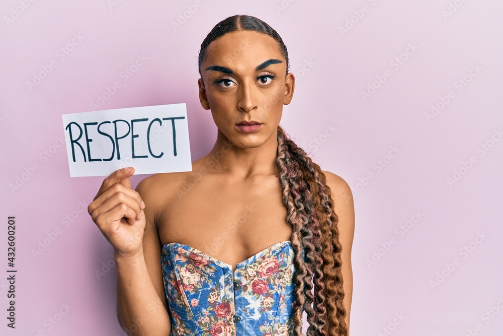 Hispanic transgender man wearing make up and long hair holding respect message thinking attitude and sober expression looking self confident Hispanic transgender man wearing make up and long hair holding respect message thinking attitude and sober expression looking self confident