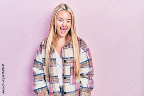 Young blonde girl wearing casual clothes winking looking at the camera with sexy expression, cheerful and happy face. © Krakenimages.com