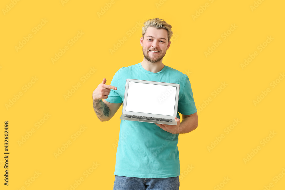 Young man with laptop on color background Young man with laptop on color background