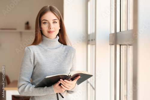 Canvas Print Young woman reading Bible at home