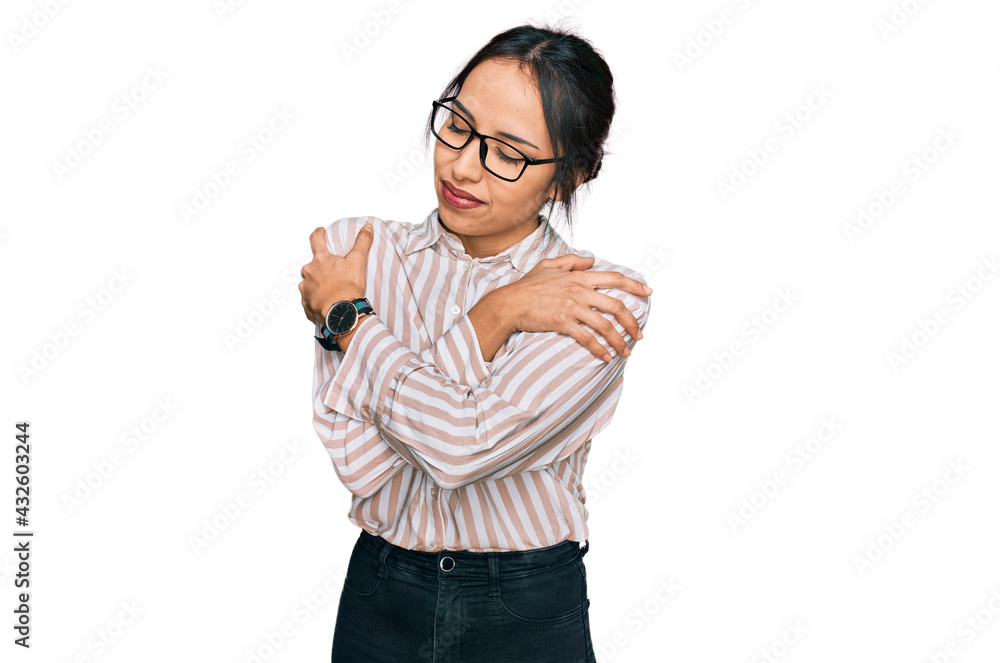 Young hispanic girl wearing casual clothes and glasses hugging oneself happy and positive, smiling confident. self love and self care Young hispanic girl wearing casual clothes and glasses hugging oneself happy and positive, smiling confident. self love and self care