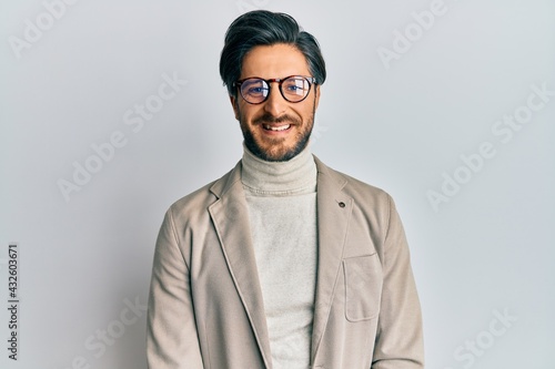 Young hispanic man wearing business jacket and glasses with a happy and cool smile on face. lucky person. © Krakenimages.com