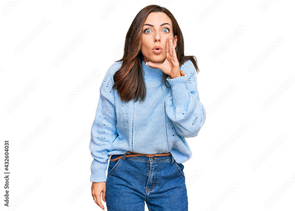 Young brunette woman wearing casual winter sweater hand on mouth telling secret rumor, whispering malicious talk conversation Young brunette woman wearing casual winter sweater hand on mouth telling secret rumor, whispering malicious talk conversation