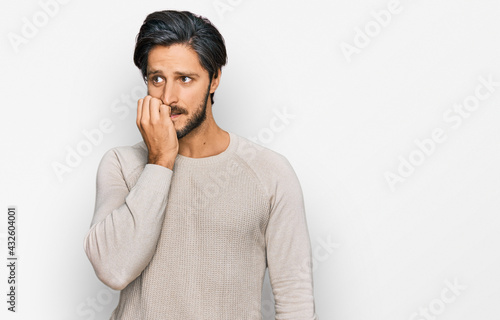 Young hispanic man wearing casual clothes looking stressed and nervous with hands on mouth biting nails. anxiety problem.