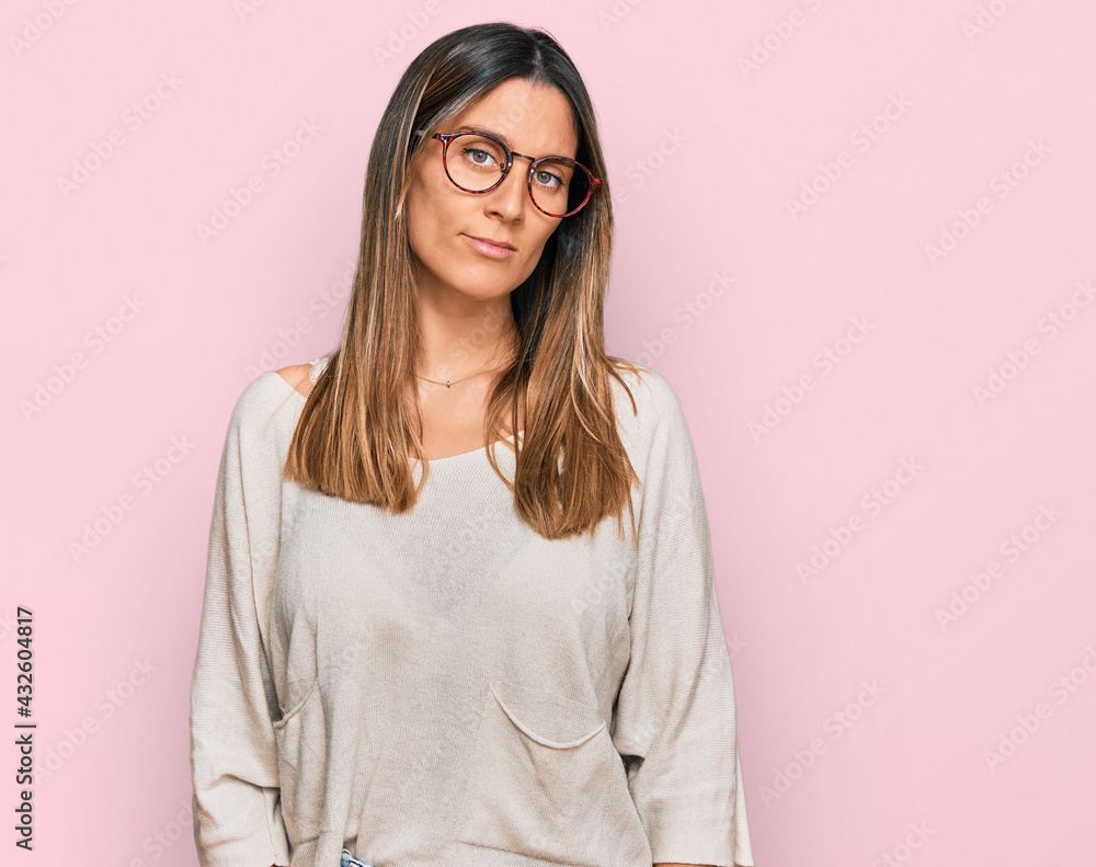 Young woman wearing casual clothes and glasses relaxed with serious expression on face. simple and natural looking at the camera.