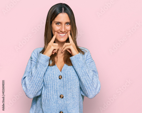 Young woman wearing casual clothes smiling with open mouth, fingers pointing and forcing cheerful smile