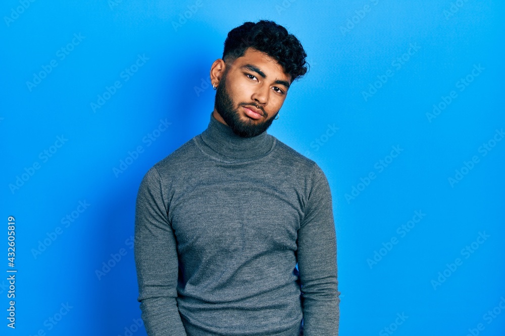 Arab man with beard wearing turtleneck sweater looking sleepy and tired, exhausted for fatigue and hangover, lazy eyes in the morning. Arab man with beard wearing turtleneck sweater looking sleepy and tired, exhausted for fatigue and hangover, lazy eyes in the morning.