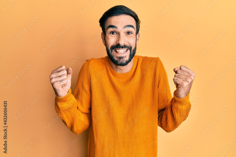 Young hispanic man wearing casual clothes celebrating surprised and amazed for success with arms raised and open eyes. winner concept. Young hispanic man wearing casual clothes celebrating surprised and amazed for success with arms raised and open eyes. winner concept.