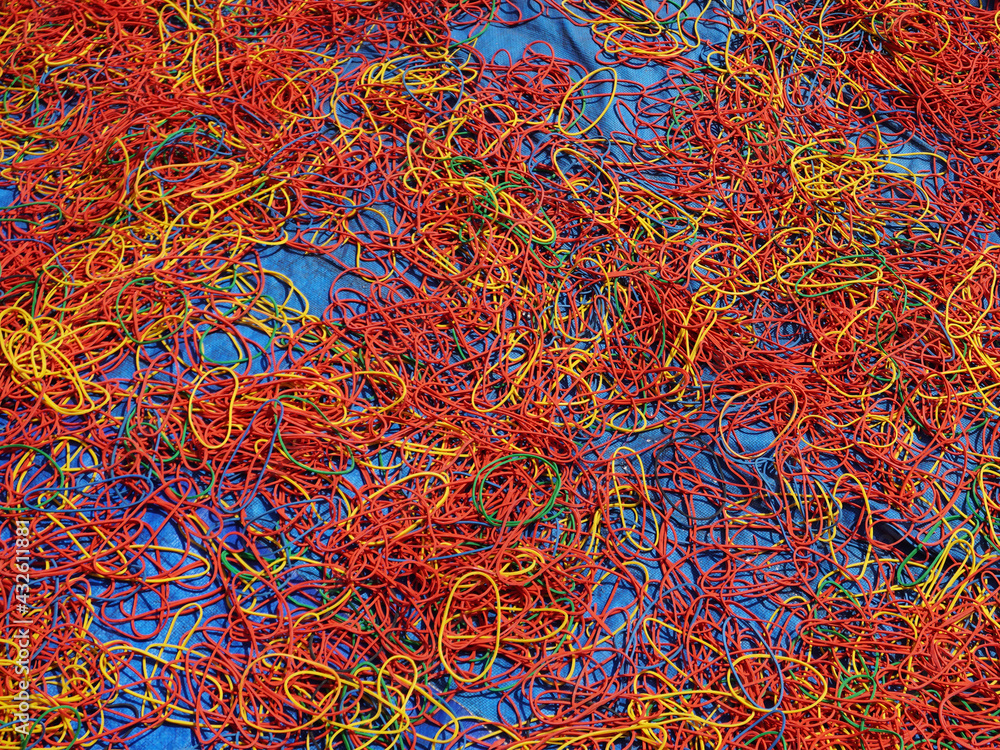 Freshly made rubber bands of different colors being sun dried, spread on the ground. Freshly made rubber bands of different colors being sun dried, spread on the ground.