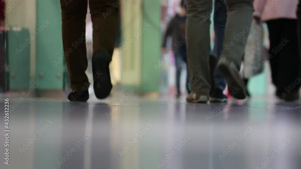 Legs of people walking in the mall. Selective focus. Blurred video. Legs of people walking in the mall. Selective focus. Blurred video.