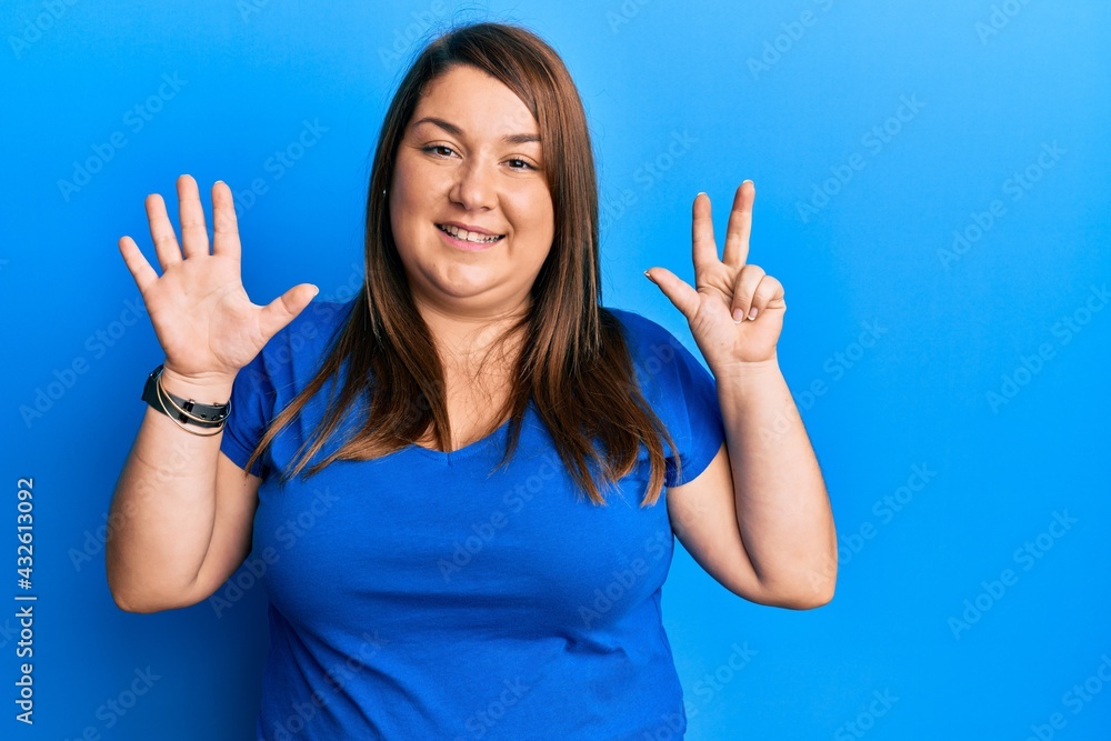 Beautiful brunette plus size woman wearing casual blue t shirt showing and pointing up with fingers number eight while smiling confident and happy. Beautiful brunette plus size woman wearing casual blue t shirt showing and pointing up with fingers number eight while smiling confident and happy.