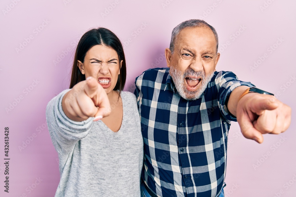 Hispanic father and daughter wearing casual clothes pointing displeased and frustrated to the camera, angry and furious with you Hispanic father and daughter wearing casual clothes pointing displeased and frustrated to the camera, angry and furious with you