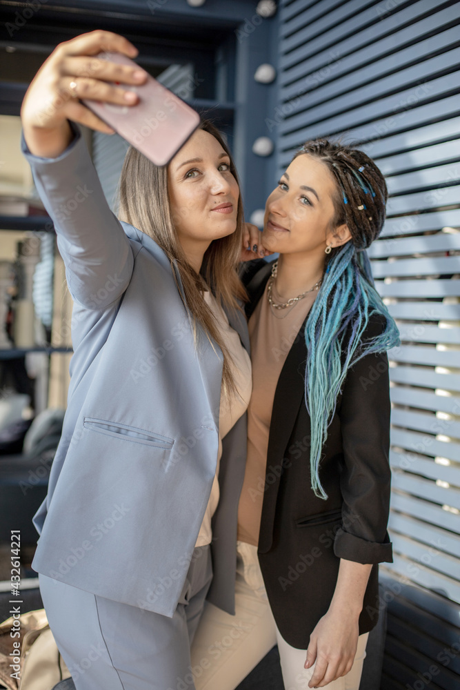 Happy female friends posing taking selfie photographing together use smartphone enjoying friendship