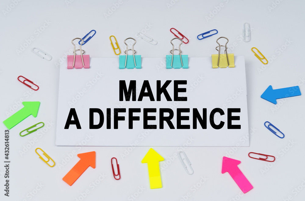 On the table there are paper clips and directional arrows, a sign that says - Make a Difference On the table there are paper clips and directional arrows, a sign that says - Make a Difference