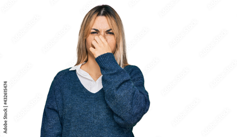 Young caucasian woman wearing casual clothes smelling something stinky and disgusting, intolerable smell, holding breath with fingers on nose. bad smell Young caucasian woman wearing casual clothes smelling something stinky and disgusting, intolerable smell, holding breath with fingers on nose. bad smell