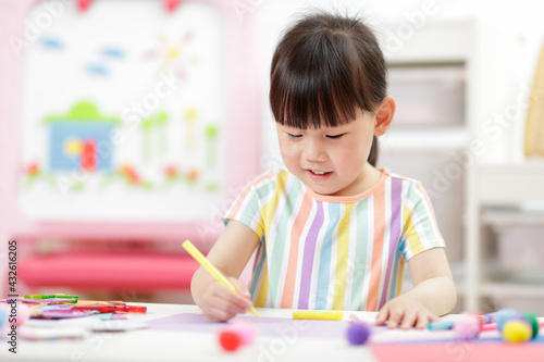 young girl making paper craft for homeschooling