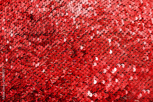 Shiny bright texture of red sequins. Fabric for fancy dresses.