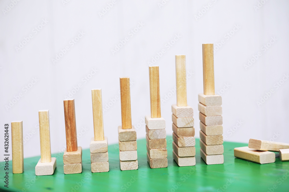 Stick wood block standing on stacked square wood blocks, abstract background in concept of winning, success, challenge, step to top position. Stick wood block standing on stacked square wood blocks, abstract background in concept of winning, success, challenge, step to top position.