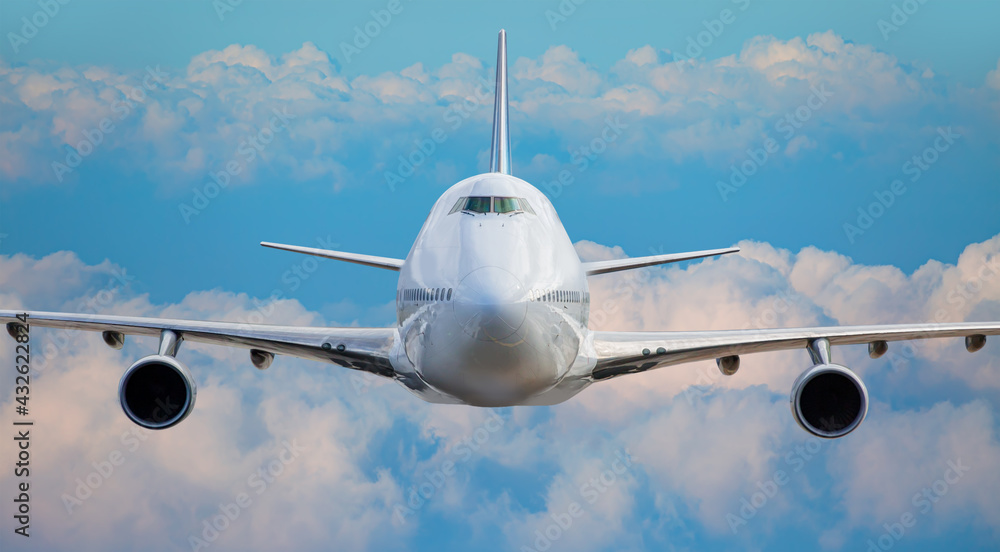 Fototapeta premium White passenger airplane over the clouds - Travel by air transport