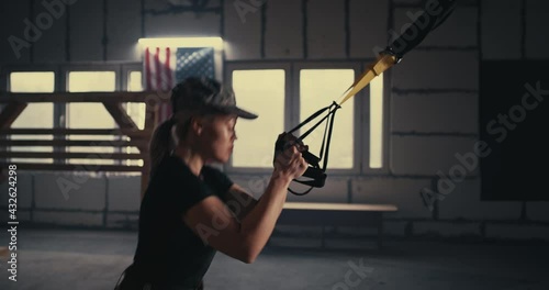 Strong military woman doing TRX lunge in gym photo