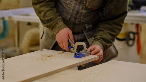 Close up. Carpenter work in the workshop. Woodwork and furniture making concept. Carpenter in the workshop marks out and assembles parts of the furniture cabinet photo