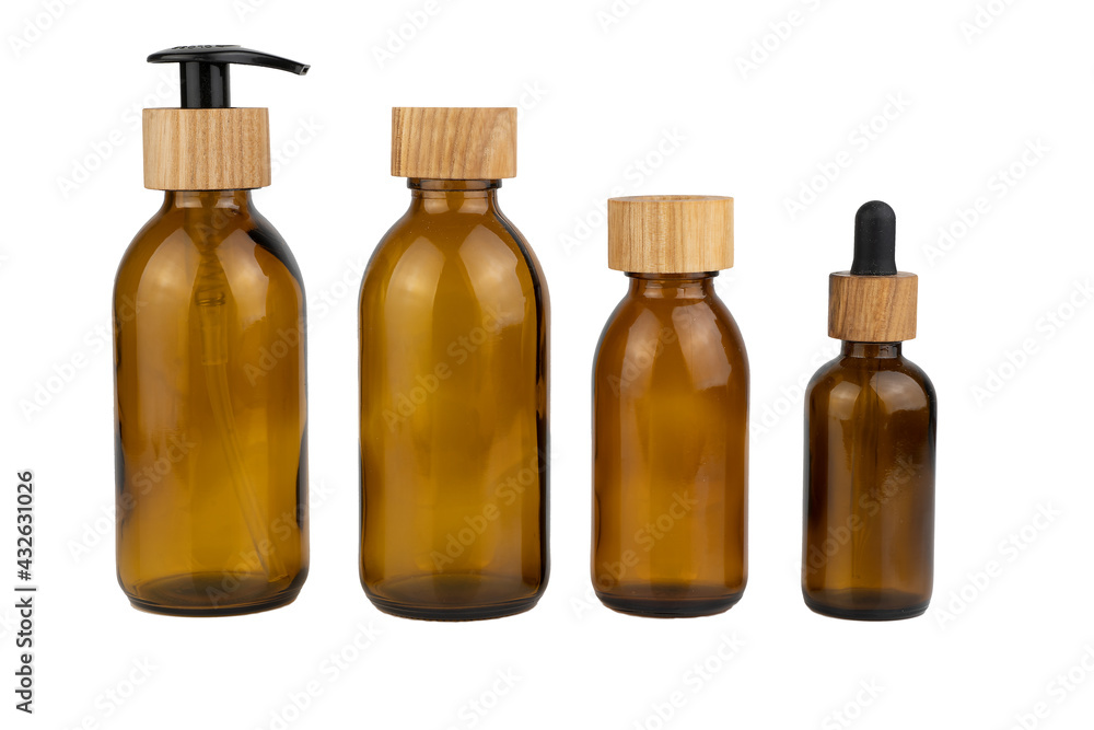 Set of assorted brown glass bottles with wooden lids for cosmetics. Dispenser with a straw and a pipette. Eco concept. Bottle for lotion, cream isolated on white background. Wooden cork. Zero waste
