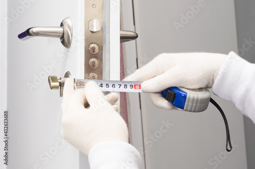 hands in gloves measure the thickness of the door close-up