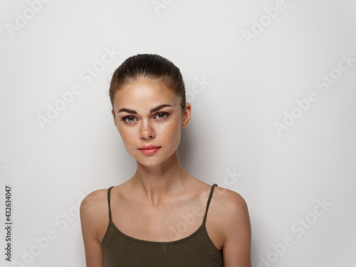young woman in a t-shirt on a light background hairstyle makeup 