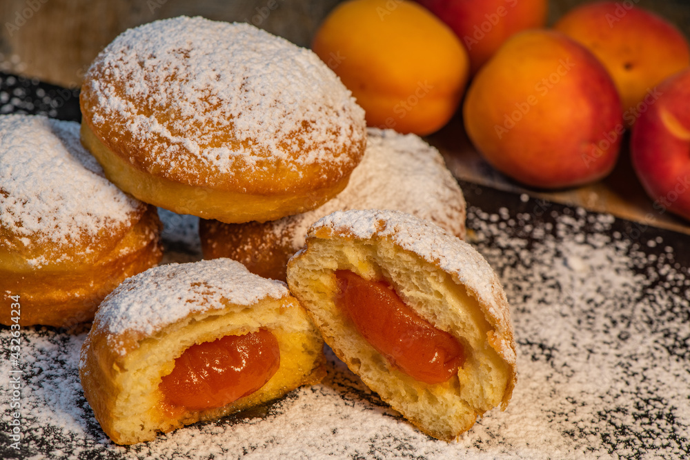 Freshly cooked Apricot jam doughnuts, referred to as jelly doughnuts, donuts in the US, The doughnuts have been fried, injected with a generous amount of jelly, jam and then dipped in caster sugar Freshly cooked Apricot jam doughnuts, referred to as jelly doughnuts, donuts in the US, The doughnuts have been fried, injected with a generous amount of jelly, jam and then dipped in caster sugar