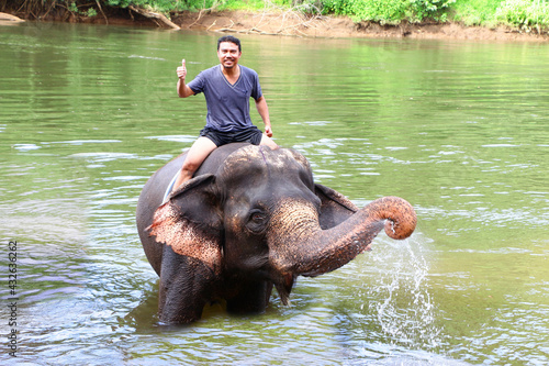 Asian Handsome Man Elephant Ride Bathing Swimming at elephant camp on Kwai River Kanchanaburi Thailand Travel Tourism Business Concept Photo
