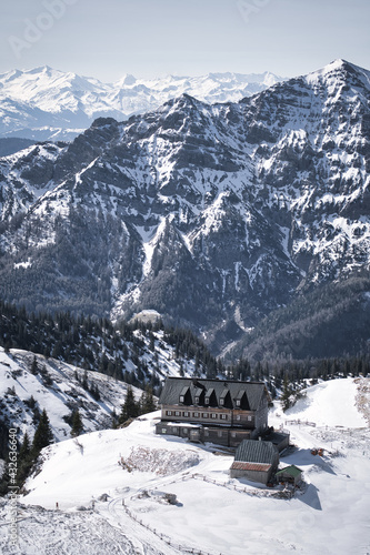 Wooden cabin in a winter landscape with snow covered mountains