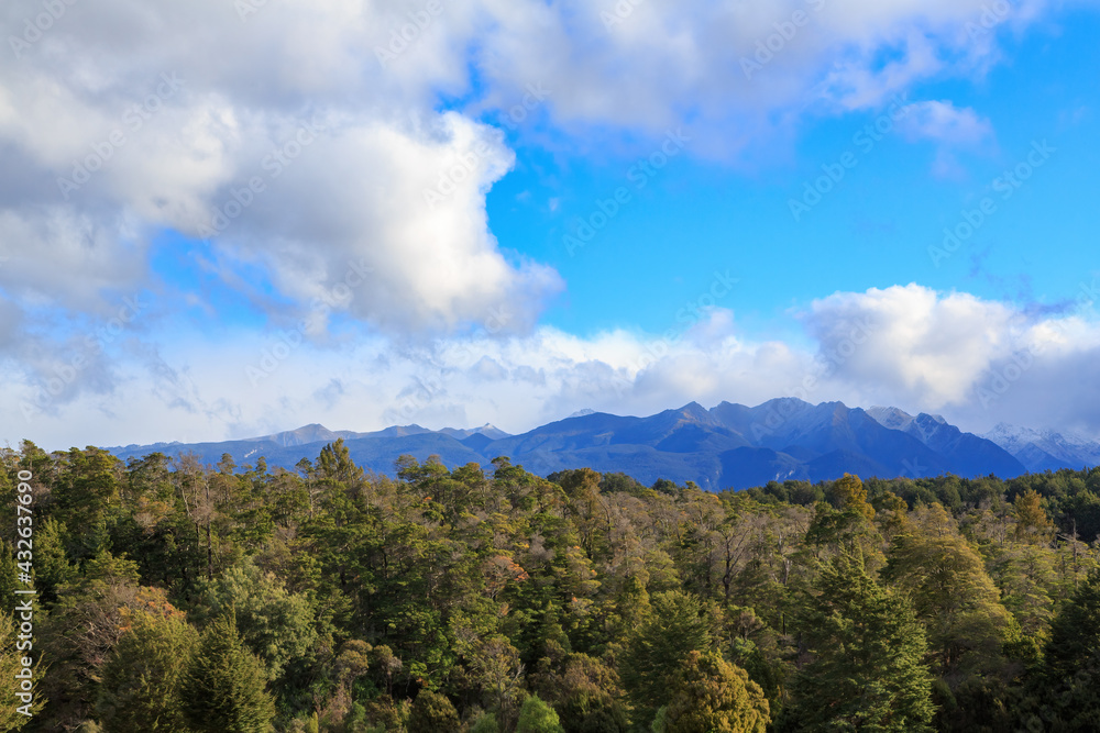Mountains rising above thick native forest in Fiordland, New Zealand