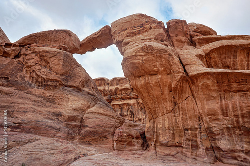 Arc or rock window formation in Wadi Rum desert stone cliffs around