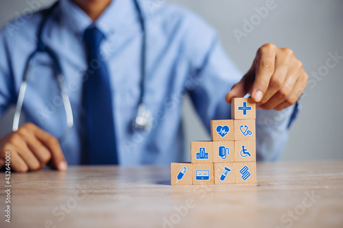 Hand arranging wood block stacking with icon healthcare medical, Insurance for your health medical, Insurance for your health concept.