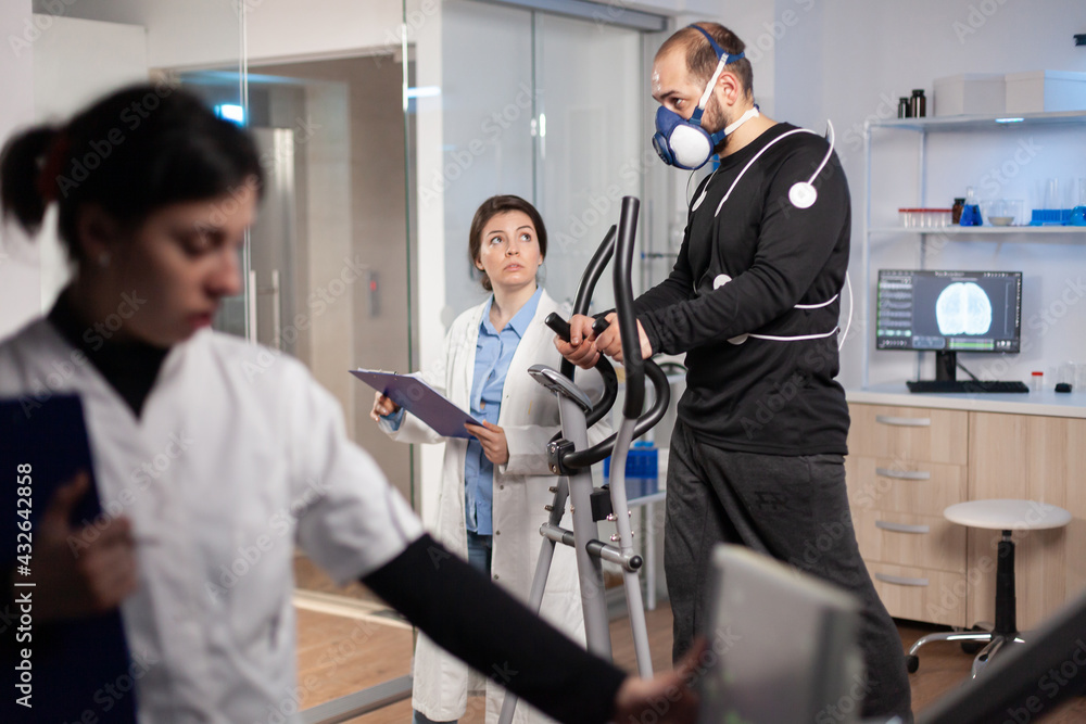 Performance athlete testing endurace in sports laboratory, running with electrodes on body for monitoring. Measuring heart rate cardio examination cross. Performance athlete testing endurace in sports laboratory, running with electrodes on body for monitoring. Measuring heart rate cardio examination cross.