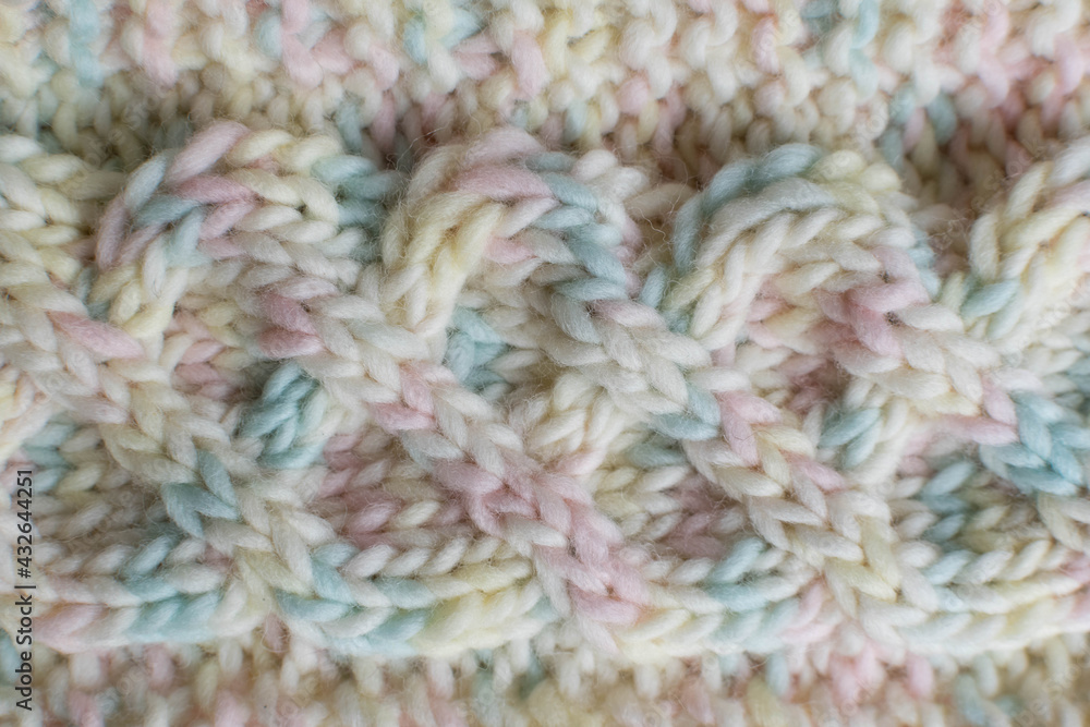 knitted wool texture in pastel shades with cable stitch detail 