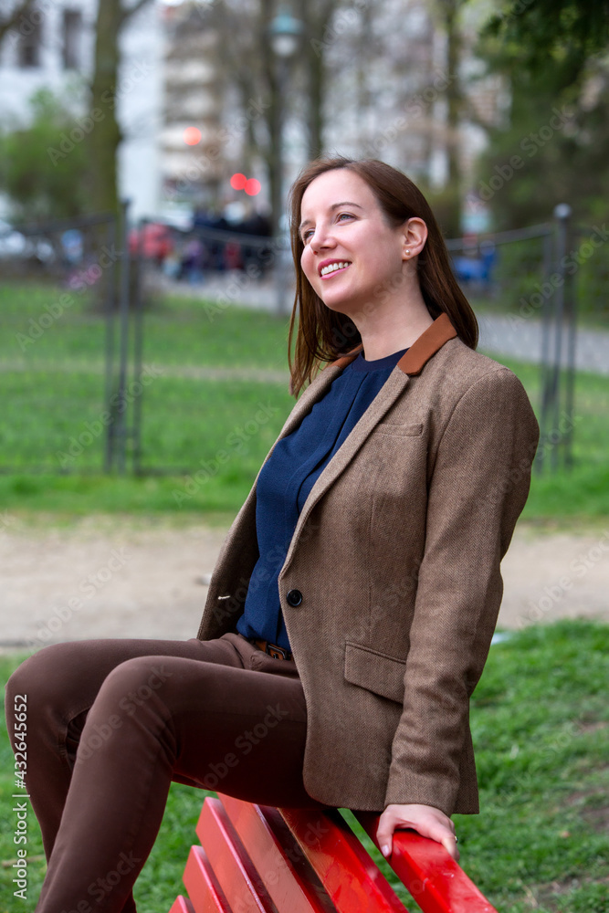 portrait of brunette woman in a suit sitting outside on a bench portrait of brunette woman in a suit sitting outside on a bench