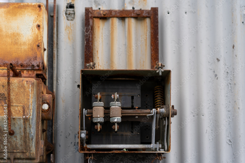 Naklejka premium old rusty electrical box of side on abandoned warehouse