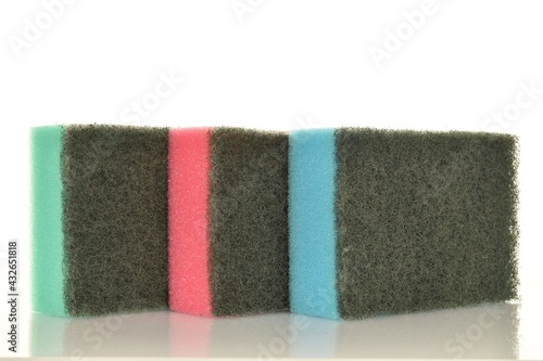 Three colored foam sponges, close-up, isolated on white.