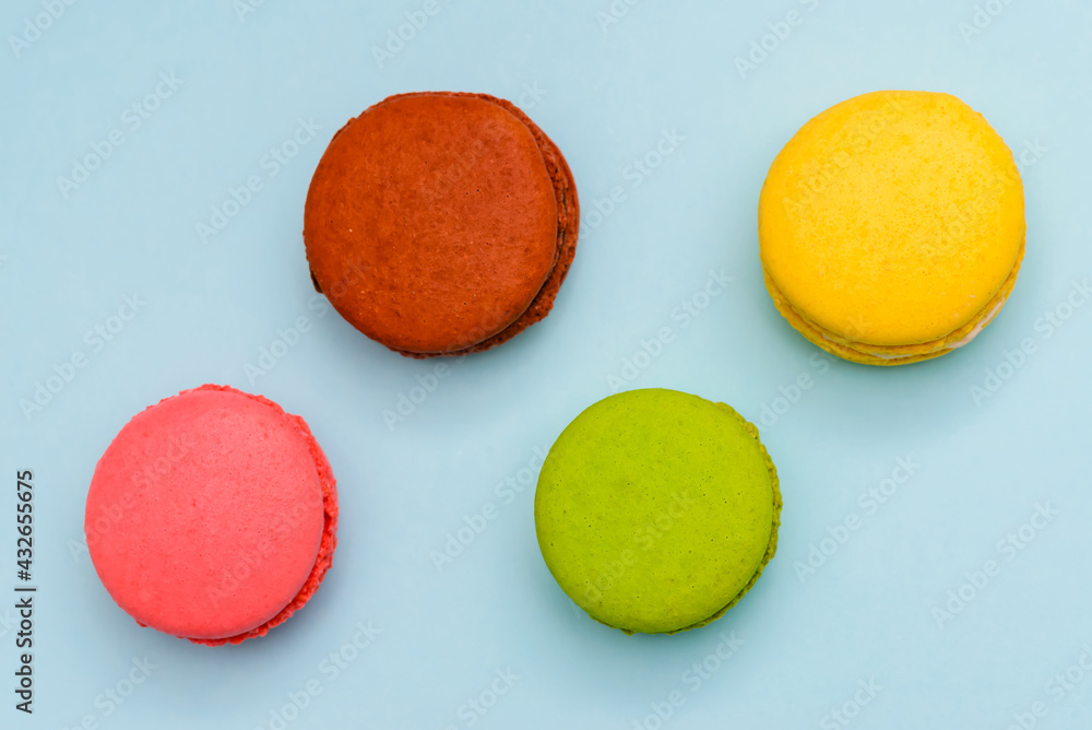 multicolored macaron cakes on a blue paper background multicolored macaron cakes on a blue paper background