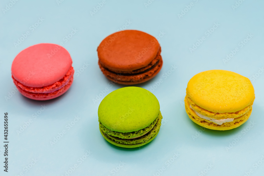 multicolored macaron cakes on a blue paper background multicolored macaron cakes on a blue paper background