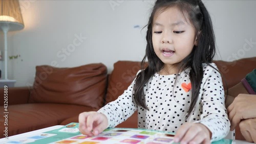 Smart Asian child girl happily reading book