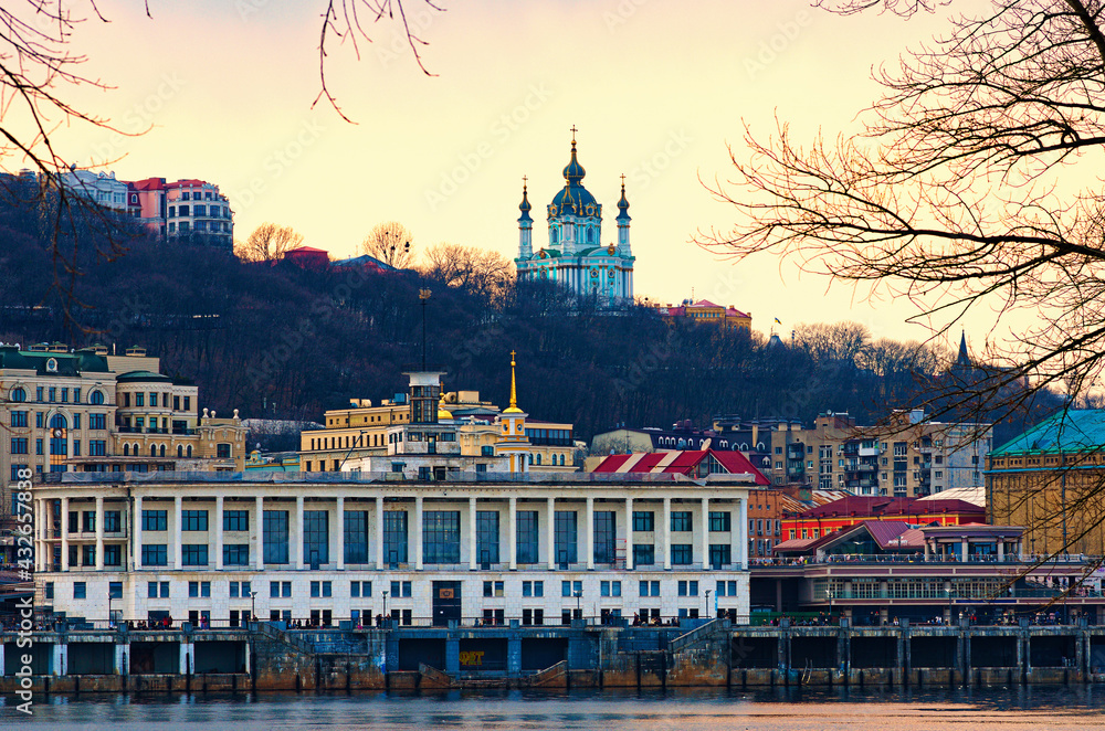 Kyiv, Ukraine-March 28, 2021:Scenic sunset landscape view of Poshtova Square with white River Port building and other historical buildings. Embankment of Dnipro River