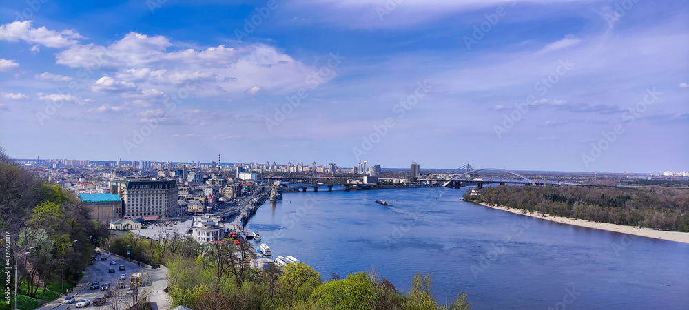 Trukhaniv Island. Dnieper (Dnipro) River. Houses on the shore in Kyiv. View of green trees in the park. The bridge in the distance. Kiev. Ukraine. Europe
