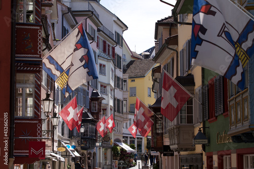 Old medieval alley with beautiful oriels named Augustinergasse at the old town of Zurich with Swiss flags on both sides. Photo taken May 8th, 2021, Zurich, Switzerland. © Michael Derrer Fuchs
